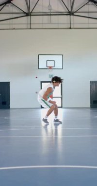 Dikey video: Salya akıtan basketbol, spor giyimli erkek sporcu kapalı sahada koşuyor. fitness, egzersiz, eğitim, rekabet, çeviklik, eylem