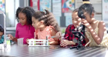 Okulda, bir sınıfta, çeşitli genç öğrencilerden oluşan bir grup bir kimya deneyi yapıyor. Test tüpleri ve deney tüpleri üzerinde yoğunlaşmışlar. Kimya posterleri ve işaretleriyle çevrelenmişler. Değiştirilmemişler..