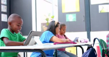 Okulda, çocuklar tablet kullanıyor ve sınıfta birlikte çalışıyorlar. Eğitim, teknoloji, işbirliği, öğrenme, öğrenciler, dijital, değiştirilmemiş, yavaş çekim
