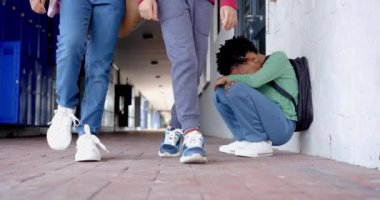 Okul koridorunda yürürken, çocuklar duvarın önünde otururken geçen öğrenciler. Eğitim, çocukluk, sırt çantası, değiştirilmemiş, yavaş çekim