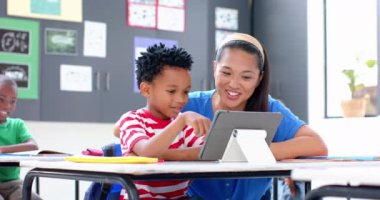 Okulda, öğretmen ve öğrenci sınıfta birlikte tablet kullanıyorlardı, gülümsüyorlardı. Eğitim, teknoloji, öğrenme, dijital, öğretim, etkileşim, değiştirilmemiş, yavaş çekim
