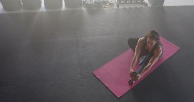 Yoga minderinde gerilme, spor salonunda egzersiz yapan güçlü formda bir kadın, esnekliğe odaklanma, kopyalama alanı. Spor, spor, kadın, sağlık, sağlık, egzersiz
