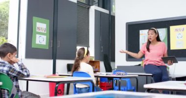 Sınıfta öğretmenlik, okulda sıralarda oturan öğrencilerle ilgilenen bir kadın, fotokopi odası. Eğitim, öğrenme, müdahale, etkileşim, akademik, öğretim üyesi, değiştirilmemiş, yavaş çekim