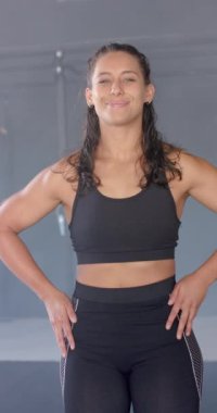 Dikey video: Spor kıyafetleri giymiş, elleri kalçasında gülümseyen kadın. Fitness, egzersiz, aktif yaşam tarzı, güç, kararlılık
