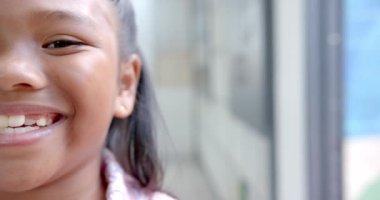 Gülümseyen çocuk okul koridorunda mutluluk ve heyecan gösteriyor, kopyalama alanı. Çocukluk, neşe, öğrenci, değişmemiş, yavaş çekim