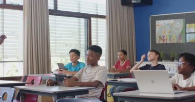 Okulda, öğrenciler tablet ve dizüstü bilgisayar kullanıyor, öğretmenle yakınlaşıyorlar. Eğitim, teknoloji, öğrenme, etkileşimli, öğretim, dijital