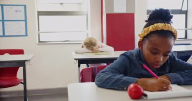 Okulda, sınıftaki kız dinlenme masasında, yorgun görünüyor. Eğitim, yorgunluk, öğrenci, can sıkıntısı, öğrenme, çocukluk