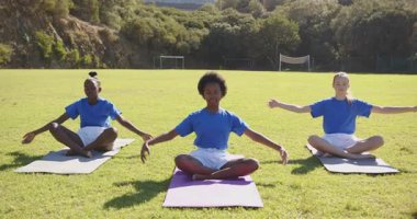 Yoga çalışması, açık hava okulunda minderlerin üzerinde oturan üç kız. Kızlar, egzersiz, sağlık, meditasyon, aktivite