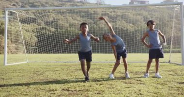 Futbol sahasında ısınan, okul formalı çocuklar maçtan önce ısınıyor. Spor, takım çalışması, egzersiz, ısınma, çocuklar, açık hava