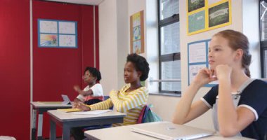 Okulda, sıralarda oturan üç kız, sınıfta dikkatle dinliyorlardı. Eğitim, öğrenim, öğrenim, kız öğrenciler, çocuklar, konsantrasyon