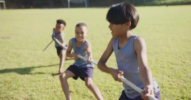 Halat çekme oyunu oynuyorlar, üç çocuk okul sahasında dışarıda eğleniyorlar. Çocuklar, takım çalışması, eğlence, oyun alanı, egzersiz, yarışma