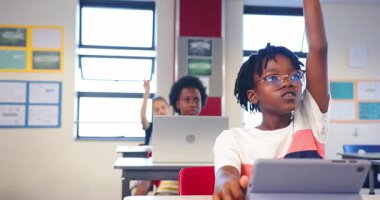 Okulda, kız öğrenciler sınıfta dizüstü bilgisayar ve tablet kullanıyorlar, öğrenmeye odaklanıyorlar. Eğitim, teknoloji, dijital, aygıtlar, öğrenim