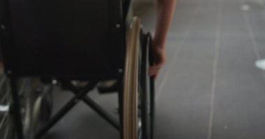 Tekerlekli sandalyedeki öğrenci, bağımsız olarak okul koridorunda ilerliyor. Erişilebilirlik, bağımsızlık, eğitim, yetkilendirme, dahil etme, çeşitlilik