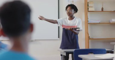 Okulda, elinde tablet olan ve sınıfta kendini güvenle gülümseyen bir çocuk vardı. Eğitim, teknoloji, sunum, güven, öğrenme, ergenlik