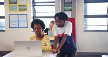 Okulda, kız öğrenciler sınıfta dizüstü bilgisayar kullanarak proje üzerinde çalışıyorlar. Eğitim, takım çalışması, öğrenme, işbirliği, teknoloji, öğrenim