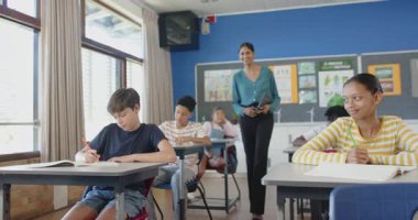 Okulda, öğrenci gülümseyip dinlerken öğretmen elinde tablet tutuyordu. Eğitim, teknoloji, öğretim, öğrenme, etkileşim, danışmanlık