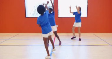 Okulun spor salonunda basketbol oynamak, kızların top sürme ve takım çalışması becerileri. Spor, egzersiz, spor, kızlar, antrenman