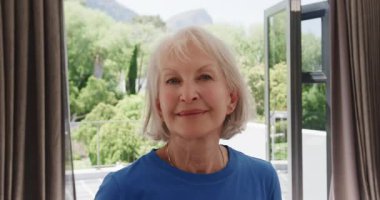 Gülümseyen son sınıf öğrencisi pencereleri açık güneşli bir günün tadını çıkarıyor. Yaşlılar, mutluluk, rahatlama, güneş ışığı, yaşam tarzı, rahatlık.