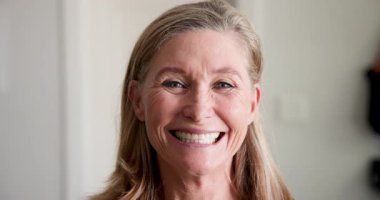 Kıdemli kadın Noel ağacını süslüyor, evde bayram ruhunun tadını çıkarıyor. Kutlama, dekorasyon, mevsimlik, gelenek, yaşlılar