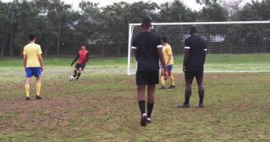 Çimenli sahada koşan futbolcular, oyunlara odaklanmış durumdalar. Sporcular, takım çalışması, yarışma, spor, egzersiz, fitness