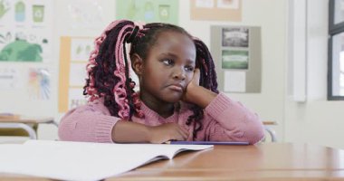 Okulda, masasında açık bir defterle hayal kuran genç bir kız sıkılmış hissediyordu. Çocukluk, eğitim, dikkat dağınıklığı, sınıf, öğrenme