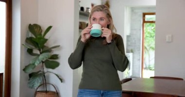 Gülümseyen son sınıf öğrencisi kadın elinde kahve fincanıyla, sıcak tatilin tadını çıkarıyor. Yaşlılar, mutluluk, rahatlama, yaşam tarzı, evcil, boş zaman