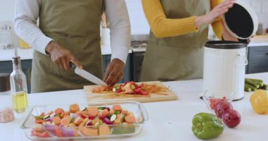 Sebze hazırlamak ve gübreleme artıkları, modern mutfakta çalışan çok ırklı bir çift. Yemek pişirme, sürdürülebilirlik, çevre dostu, sıfır atık, geri dönüşüm, aşçılık