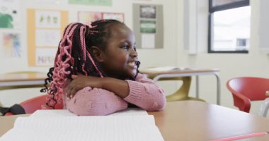 Sınıfta, Afrika kökenli Amerikalı bir kız elinde kalem, defterine yazmaya hazır, okulda. kız, öğrenme, eğitim, öğrenim, akademisyenler, okul