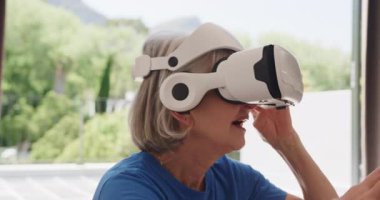 Dışarıda sanal gerçeklik kulaklığı keşfeden, evde derin deneyimleri olan son sınıf bir kadın. teknoloji, yenilik, keşif, yaşlılar