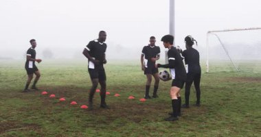 Futbolcular sisli sahada antrenman yapıyor, takım çalışmasına ve yeteneklerine odaklanıyor. antrenman, antrenman, spor, egzersiz, açık hava, sporcular