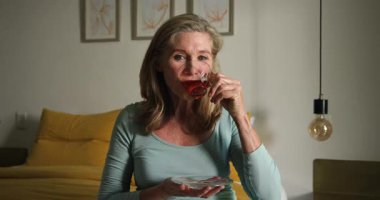 Gülümseyen son sınıf öğrencisi kadın sıcak bir içecekle evdeki sıcacık anın tadını çıkarıyor. Yaşlılar, rahatlama, emeklilik, ev, yaşam tarzı, çay