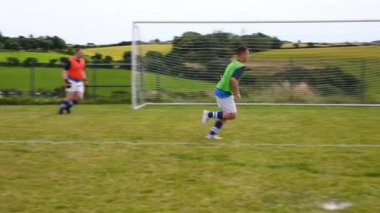 Oyuncular yeşil formalar giyerek çim tarlasında deniz kenarına antrenman yapıyorlar. Sporcular, takım çalışması, yarışma, spor, antrenman, egzersiz