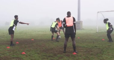 Futbolcular sisli sahada antrenman yapıyor, takım çalışmasına ve yeteneklerine odaklanıyor. Spor, antrenman, sis, egzersiz, atletik, yarışma