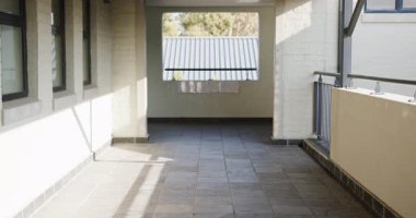 Okul koridorunda mavi sırt çantası taşıyan, aşağı bakan genç bir kız. Eğitim, akademik, genç