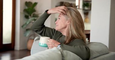 Evde dinleniyor, kıdemli bir kadın gülümsüyor ve elinde kahve fincanı tutuyor. Rahatlama, rahatlama, yaşam tarzı, içerik, konfor, sıcaklık