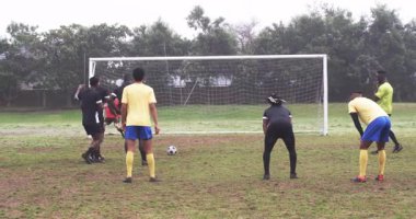 Futbolcular çimenli sahada penaltı atışına hazırlanıyor, odaklanmış ve kararlı. Spor, atlet, takım çalışması, yarışma, konsantre, açık hava