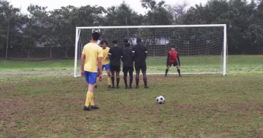 Futbolcular çamurlu sahada yarışıyor, gol girişimine odaklanıyor. rekabet, takım çalışması, spor, sporcular, açık hava, tekme