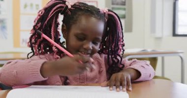 Okulda, sınıfta kalemle hayal kuran genç bir kız, düşünceli görünüyor. Eğitim, tefekkür, çocukluk, düşünme, hayal gücü, öğrenme