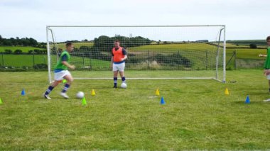 Futbolcular sahada koni ve arka planda golle antrenman yapıyorlar. Spor, antrenman, takım çalışması, atletik, egzersiz, yarışma