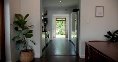 Şık aletleri olan modern mutfak ve yemyeşil bahçeye açılan açık kapı. İç, çağdaş, tasarım, lüks, mimari, yeşillik