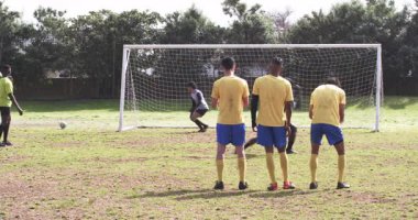 Futbolcular sahada golü kutluyor, heyecan ve takım çalışması gösteriyorlar. Futbol, takım ruhu, kutlama, zafer, sportmenlik, enerji