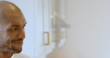 Gülümseyen Afrikalı Amerikalı adam evinde rahat bir mutfakta, fotokopi odasında eğleniyor. Kutlama, mutluluk, yaşam tarzı, yemek pişirme, parti, neşeli