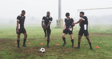 Futbolcular sisli sahada ısınıyor, antrenman için hazırlanıyorlar. Sporcular, egzersiz, takım çalışması, antrenman, spor, hazırlık