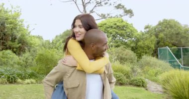 Çeşitli çok ırklı çiftler, yemyeşil parkta oynaşıp eğleniyorlar. çeşitlilik, romantizm, açık hava, eğlence, doğa, ilişki