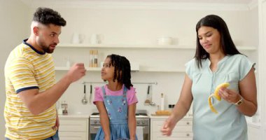 Aile mutfakta eğleniyor, gülümseyerek taze meyve hazırlıyor. Yemek pişirme, bağ kurma, mutluluk, takım çalışması, sağlıklı, yaşam tarzı