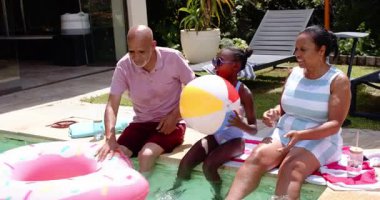 Farklı büyükbabalar ve torunlar havuz başında eğleniyor, el çırpıyor ve birlikte gülümsüyorlar. Aile, bağ, yaz, mutluluk, eğlence, kahkaha