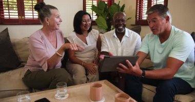 Oturma odasında, evde tablete bakarken kıdemli arkadaşlar gülüyor ve sohbet ediyorlardı. Yaşlılar, arkadaşlık, teknoloji, iletişim, boş zaman, emeklilik