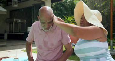 Çeşitli büyükbabalar havuz başında güneşli bir günün keyfini çıkarıyorlar, birlikte gülüyorlar ve dinleniyorlar. Aile, yaz tatili, rahatlama, boş zaman, bağ, bahçede