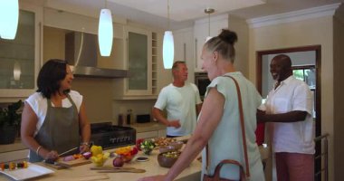 Son sınıf öğrencisi kadın modern mutfakta şiş hazırlıyor, evde arkadaşıyla gülüyor ve sohbet ediyor. Aşçılık, arkadaşlık, aşçılık, yaşam tarzı, mutluluk, eğlence