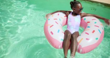 Yüzme havuzunda yüzen gülen kız güneşli günün tadını çıkarıyor. Yaz, rahatlama, rahatlama, yüzme, havuz kenarı, tatil